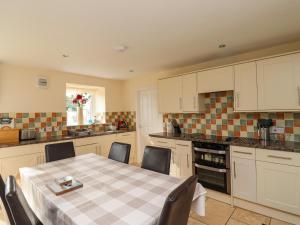 a kitchen with a table and chairs in a kitchen at Sunshine Cottage in Seahouses