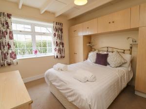 a bedroom with a large bed with towels on it at Sunshine Cottage in Seahouses