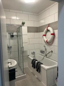 La salle de bains est pourvue d'une douche, d'une baignoire et d'un lavabo. dans l'établissement FeWo Akri, à Ribnitz-Damgarten