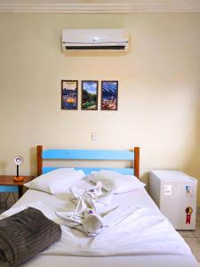 a bed with white sheets and a blue headboard at Bonito HI Hostel e Pousada in Bonito