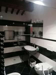 a black and white bathroom with a sink and toilets at CASALE ANTONELLA in Bastia Umbra