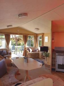 - un salon avec un canapé et une table dans l'établissement Sandy Toes Hoburne Devon Bay Holiday Park., à Paignton
