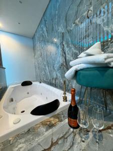 uma casa de banho com uma banheira e uma garrafa de vinho em B&B DONNA SISINA em Terzigno
