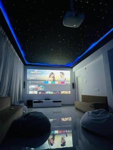 Luxurious Independent villa in Gachibowli في حيدر أباد: غرفة معيشة مع تلفزيون كبير مع أضواء زرقاء