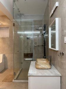 baño con ducha y puerta de cristal en Luxurious Independent villa in Gachibowli en Hyderabad