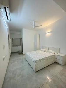 a white bedroom with a bed and a ceiling at Luxurious Independent villa in Gachibowli in Hyderabad