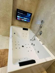 a white bath tub with a tv in a bathroom at Luxurious Independent villa in Gachibowli in Hyderabad