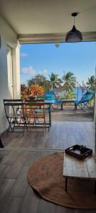 d'une terrasse avec une table et des chaises et une vue sur la plage. dans l'établissement Turquoise studio remarquable vue mer, au Diamant