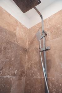 a shower with a shower head in a bathroom at Le Gamay Appartement 6 personnes in Tours