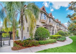 una gran casa con palmeras y una acera en Luxury Model Townhome - 5 minutes from Disney, en Orlando