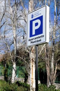 un cartello di parcheggio su un palo di fronte agli alberi di SUKI HOUSE Chalet 1 a Madrid