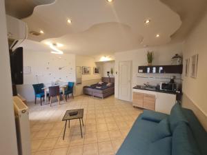 a living room with a blue couch and a table at Csever Apartman in Tata