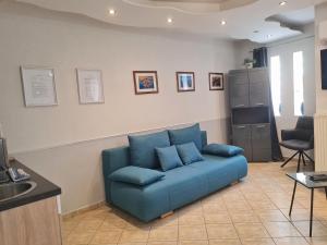 eine blaue Couch im Wohnzimmer in der Unterkunft Csever Apartman in Tata