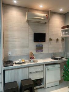 a kitchen with a counter with a sink and a tv at Alugo flat suítes mobiliado com área de lazer in Araguaína +1 photo
