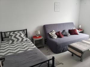 een woonkamer met een bank en een bed bij Appartement T3 3 étoiles à 4 km de la plage in Tarnos