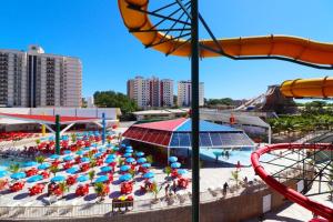 einen Wasserpark mit einem Haufen Stühle und Sonnenschirme in der Unterkunft Piazza diRoma c acesso Parque diRoma in Caldas Novas