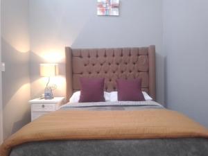 1 dormitorio con 1 cama grande con almohadas moradas en Hotel Suspiro, en San Miguel de Allende