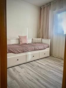 Cama blanca en habitación con ventana en Apartamento en primera linea frontal al mar, en El Borseral