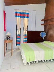 um quarto com uma cama, uma mesa e uma janela em CASA JOAQUÍN HOSTAL em Oaxaca City