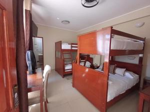 a room with two bunk beds and a television at Arena Hostal in Paracas