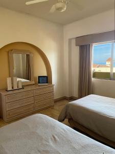 a bedroom with two beds and a mirror and a window at Amazing Ocean View in Puerto Vallarta