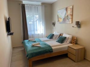 a bedroom with a large bed with a window at Vitality Apartman in Makó
