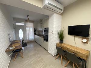 a living room with two tables and a television on the wall at Vitality Apartman in Makó
