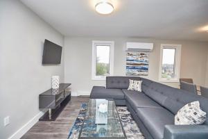 uma sala de estar com um sofá e uma mesa em Clifton Hill Hideaway 3B - Two Bedroom Condo em Cataratas do Niágara