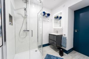 uma casa de banho com um chuveiro e uma porta azul em Market Square Apartments Bushmills em Bushmills