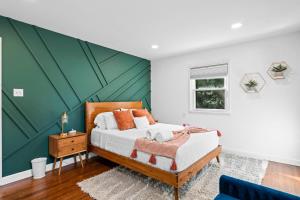 a bedroom with a bed with a green accent wall at Alexandria VA, Washington DC Home away from home in Alexandria
