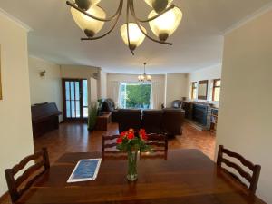 a dining room with a table with a vase of flowers at Doordrift Extension in Cape Town