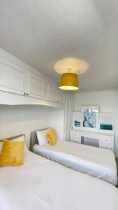 um quarto com duas camas e uma luz amarela em M6 Jct 10, 2 Bed House Wolverhampton-Walsall em Willenhall