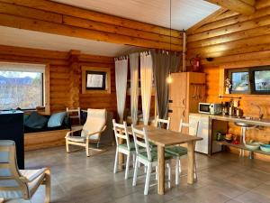 a kitchen and dining room with a table and chairs at Mountain Log Cabin O Lobo in Cabeceiras de Basto