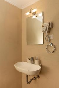 a bathroom with a white sink and a mirror at Iason Studios in Chania