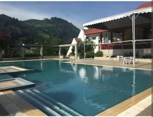 a large swimming pool in front of a house at Bukit Tinggi Fuchsia Hillhomes in Bukit Tinggi
