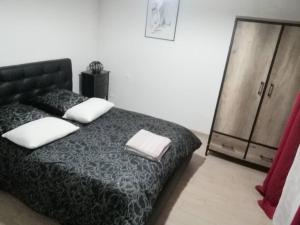 - une chambre avec un lit noir et une commode dans l'établissement Havre de paix : appartement de standing, à Valenciennes