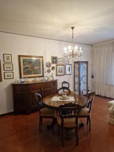 a dining room with a table and chairs and a chandelier at Kate's house in Padova