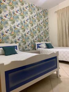 Appartamento Perla في فلوره: غرفة نوم بسريرين وورق جدران بالطيور +16 صورة