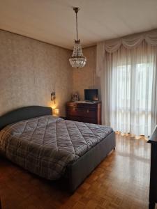 a bedroom with a bed and a television and a chandelier at Kate's house in Padova