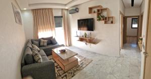 a living room with a couch and a table at Zenata ocean park appartement in Mohammedia
