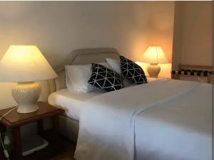 dwa łóżka w pokoju z dwoma lampami na stołach w obiekcie Bukit Tinggi Fuchsia Hillhomes w mieście Bukit Tinggi