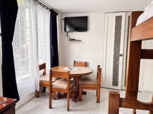 a dining room with a table and chairs and a tv at Apartaestudio Cerca al Parque Lago in Pereira