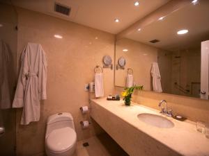 y baño con lavabo, aseo y espejo. en Hotel Las Americas Casa de Playa, en Cartagena de Indias