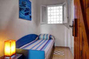 a small bedroom with a blue couch and a window at Raffaela's House - (San Montano) in Massa Lubrense
