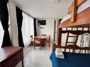a bedroom with a bunk bed and a dining room at Apartaestudio Cerca al Parque Lago in Pereira