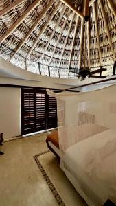 a room with a ceiling with a bed in it at El Alquimista Yoga Spa in Zipolite