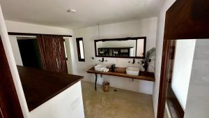 El Alquimista Yoga Spa في زيبوليت: حمام مع حوض ومرآة على الحائط