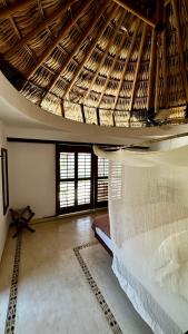 um quarto com uma cama grande e um tecto de madeira em El Alquimista Yoga Spa em Zipolite