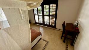 a bedroom with a bed and a table and a window at El Alquimista Yoga Spa in Zipolite