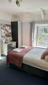 a bedroom with a large bed with a window at Blue Bell Inn in Embleton